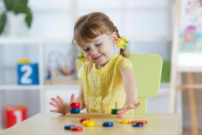 little girl playing table toys